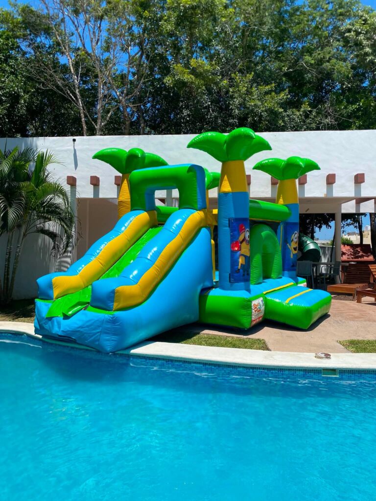 Castillo inflable verde con palmeras y resbaladilla de Divertiplaya en Playa del Carmen