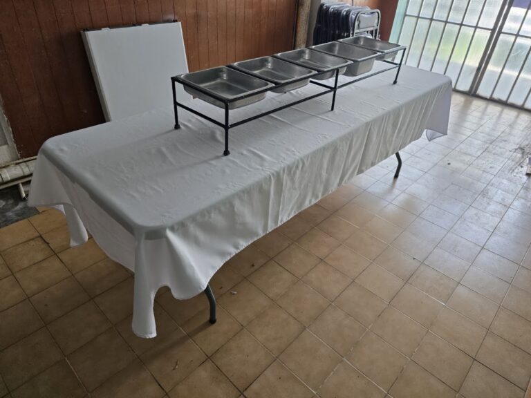 Mesa rectangular con mantel blanco y soporte metálico para buffet de Alquiladora Condesa en CDMX