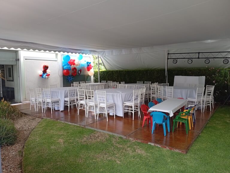 Montaje de carpa con mesas, sillas blancas y sillas infantiles de colores de Alquiladora Petit en CDMX