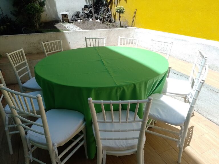 Mesa redonda con mantel verde y sillas Tiffany blancas en renta con Alquiladora Petit en CDMX