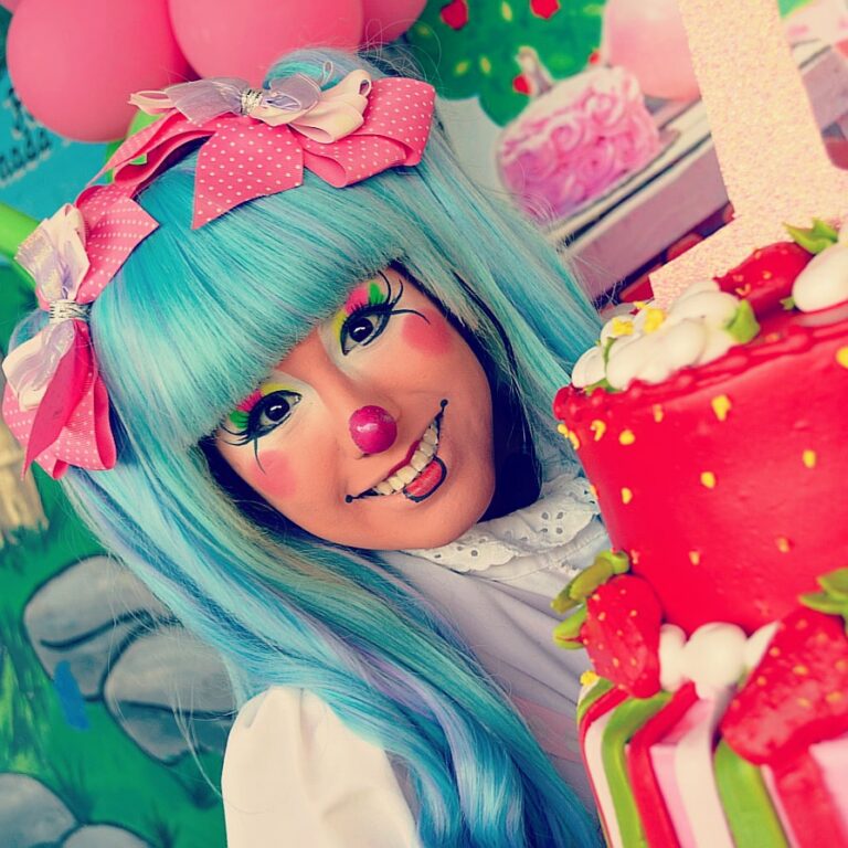 Payasita Motita en una fiesta con pastel de fresas y globos